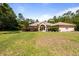 A view of the home showcasing its arched entryway, well-maintained lawn, and mature landscaping at 21939 Sw 85Th Loop, Dunnellon, FL 34431