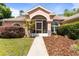 Charming single-story home with a screened entryway, manicured landscaping, and walkway leading to the front door at 21939 Sw 85Th Loop, Dunnellon, FL 34431