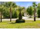 Lush front yard with swaying palm trees and a glimpse of the home's detached three-car garage at 21939 Sw 85Th Loop, Dunnellon, FL 34431