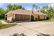 Spacious three-car garage with a side entrance and beautifully landscaped surroundings at 21939 Sw 85Th Loop, Dunnellon, FL 34431