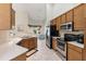 Bright kitchen with stainless appliances, wooden cabinets, and a view to the living area at 21939 Sw 85Th Loop, Dunnellon, FL 34431
