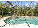 Swimming pool with a built-in hot tub and screened enclosure, surrounded by trees at 21939 Sw 85Th Loop, Dunnellon, FL 34431