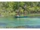 Two people enjoy canoeing in the clear water of a river surrounded by lush trees at 21939 Sw 85Th Loop, Dunnellon, FL 34431
