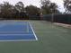 Outdoor tennis courts with basketball hoop surrounded by a fence and trees at 21939 Sw 85Th Loop, Dunnellon, FL 34431