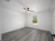 Comfortable bedroom with neutral walls and gray floors, complemented by a ceiling fan and natural light at 24354 Nw Water Oak Ave, Dunnellon, FL 34431