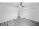 Neutral bedroom featuring gray floors, ceiling fan, and closet, next to ensuite bathroom at 24354 Nw Water Oak Ave, Dunnellon, FL 34431