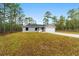 Charming single-story home featuring a gray exterior, attached garage and naturally landscaped front yard surrounded by trees at 24354 Nw Water Oak Ave, Dunnellon, FL 34431