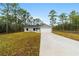 Charming single-story home featuring a gray exterior, attached garage and naturally landscaped front yard surrounded by trees at 24354 Nw Water Oak Ave, Dunnellon, FL 34431