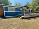 Blue single-story home featuring a wood porch, white trim, and a well-maintained yard at 25292 Ne 132Nd Ln, Fort Mc Coy, FL 32134
