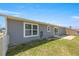 A fenced backyard features a grassy area and concrete patio, accessible through sliding glass doors at 2705 Sw 156Th Lane Rd, Ocala, FL 34473
