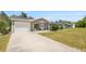 Charming single-story home with a well-manicured lawn and attached garage on a sunny day at 2705 Sw 156Th Lane Rd, Ocala, FL 34473