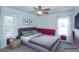 Comfortable bedroom with a gray bed, red accent wall, and natural light streaming through the windows at 2730 Sw 162Nd Street Rd, Ocala, FL 34473