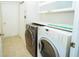 Bright laundry room featuring a washer, dryer, tile floors and ample storage space at 2730 Sw 162Nd Street Rd, Ocala, FL 34473