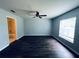 Bedroom with a ceiling fan and dark wood flooring; features large window at 38 Laurel Ct, Ocala, FL 34480