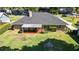 Overhead shot of the backyard featuring a covered patio, manicured lawn, mature trees, and a decorative fountain at 4424 Se 14Th St, Ocala, FL 34471