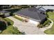 Aerial view showcasing the home, driveway, detached garage, lush lawn, and surrounding greenery at 4424 Se 14Th St, Ocala, FL 34471