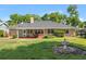 Expansive backyard with lush lawn, covered patio, mature trees, and a charming fountain, perfect for outdoor activities at 4424 Se 14Th St, Ocala, FL 34471