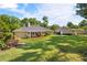 Beautiful backyard showcasing the home, covered patio, fountain, lush lawn, and mature trees creating a serene outdoor space at 4424 Se 14Th St, Ocala, FL 34471