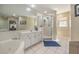 Bright bathroom with jacuzzi tub, glass shower, and white tiled floors at 4424 Se 14Th St, Ocala, FL 34471