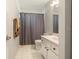 Cozy bathroom with gray shower curtain, tiled floors, and a modern vanity at 4424 Se 14Th St, Ocala, FL 34471