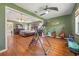 View of the main bedroom showing an exercise corner, hardwood floors, green walls and vaulted ceiling at 4424 Se 14Th St, Ocala, FL 34471
