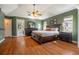 Large main bedroom with hardwood floors, vaulted ceilings, king bed and adjacent main bathroom at 4424 Se 14Th St, Ocala, FL 34471