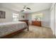 Comfortable bedroom featuring a ceiling fan, plush carpet, and bright natural light at 4424 Se 14Th St, Ocala, FL 34471