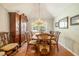 Traditional dining area showcasing detailed wood furniture, a crystal chandelier, and a bright window view at 4424 Se 14Th St, Ocala, FL 34471