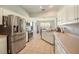 Well-lit kitchen with stainless steel appliances and white cabinets, complete with a view of the dining area at 4424 Se 14Th St, Ocala, FL 34471