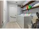 Functional laundry room featuring a washer, dryer, and ample shelf storage at 4424 Se 14Th St, Ocala, FL 34471