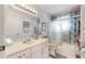 This bathroom has white cabinets and counters, with a shower and tub at 4716 Nw 34Th Pl, Ocala, FL 34482