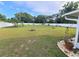 A large, well-maintained backyard features lush green grass, decorative landscaping, and a perimeter fence at 5606 Sw 107Th St, Ocala, FL 34476