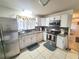 Functional kitchen featuring white cabinets, granite countertops, and stainless steel appliances at 5606 Sw 107Th St, Ocala, FL 34476