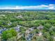 Panoramic aerial view of the property, showing its location surrounded by lush greenery, neighborhood homes, and distant city skyline at 6403 Summit Dr, Orlando, FL 32810
