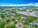 Aerial view featuring a quaint two-story home nestled among green trees and commercial buildings at 6403 Summit Dr, Orlando, FL 32810