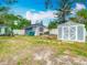 Spacious backyard featuring a charming blue building, a gray storage shed, and ample green space for leisure at 6403 Summit Dr, Orlando, FL 32810