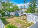 Expansive backyard with detached blue building, a gray shed, and lush green space, perfect for outdoor activities at 6403 Summit Dr, Orlando, FL 32810