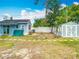 Expansive backyard with detached blue building, a gray shed, and lush green space, perfect for outdoor activities at 6403 Summit Dr, Orlando, FL 32810