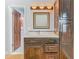 Bathroom vanity with dark wood cabinets and open door to shower at 6403 Summit Dr, Orlando, FL 32810