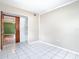 A bright bedroom with neutral walls, tile flooring, and an open closet with shelves at 6403 Summit Dr, Orlando, FL 32810