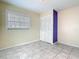 A cozy bedroom with neutral walls, tile flooring, a window, and bi-fold closet at 6403 Summit Dr, Orlando, FL 32810