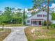 Charming blue two-story home with a covered front porch, red door, and mature landscaping at 6403 Summit Dr, Orlando, FL 32810