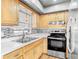 This kitchen features light wood cabinets, stainless steel appliances, and a stylish backsplash at 6403 Summit Dr, Orlando, FL 32810