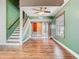 Open-concept living room featuring hardwood floors, staircase, and a ceiling fan at 6403 Summit Dr, Orlando, FL 32810