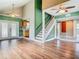 An open-concept living room with hardwood floors, a staircase, and glass patio doors at 6403 Summit Dr, Orlando, FL 32810