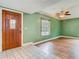 Bright, welcoming living room with hardwood floors, a large window, and an entry door at 6403 Summit Dr, Orlando, FL 32810