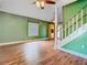 Cozy living room with hardwood floors, staircase, and natural light streaming through the window at 6403 Summit Dr, Orlando, FL 32810