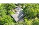 Aerial view of the home showcasing its roof, screened patio, driveway, and surrounding lush landscaping and mature trees at 733 Se 67Th Ln, Ocala, FL 34480