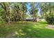 Large backyard area with mature trees and a screened lanai offers a serene outdoor space at 733 Se 67Th Ln, Ocala, FL 34480