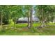 Expansive backyard featuring a screened-in patio, lush green lawn and mature trees providing ample shade and privacy at 733 Se 67Th Ln, Ocala, FL 34480